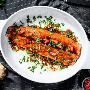 Cooking of salmon fillet teriyaki. Black background. Top view