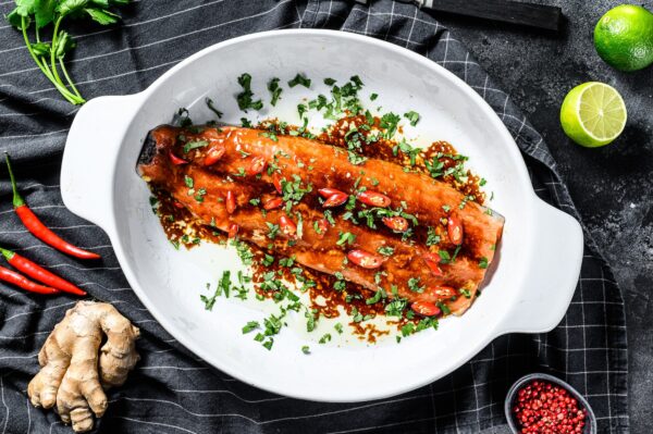 Cooking of salmon fillet teriyaki. Black background. Top view