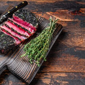 Homemade Cut Grilled Sesame Tuna steak on a cutting board.