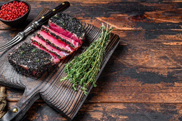 Homemade Cut Grilled Sesame Tuna steak on a cutting board.