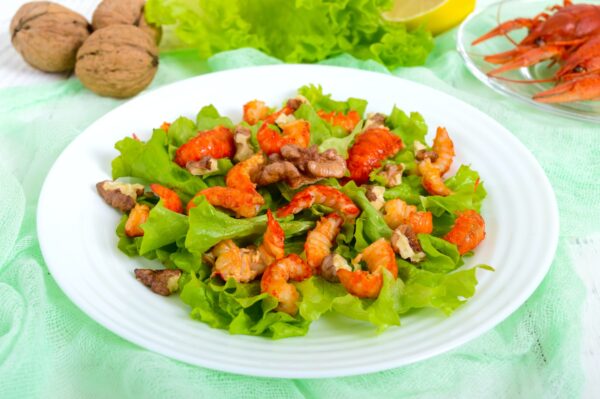 Light dietary spicy salad of lettuce, seafood (crawfish, shrimp) and walnuts