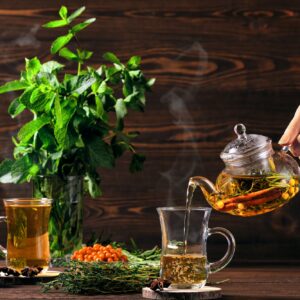 Pouring hot herbal tea with sea buckthorn