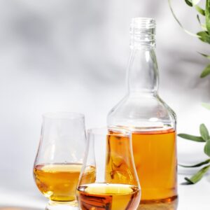 Scotch Whiskey in special glasses and bottle, white background with negative space