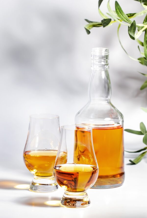 Scotch Whiskey in special glasses and bottle, white background with negative space